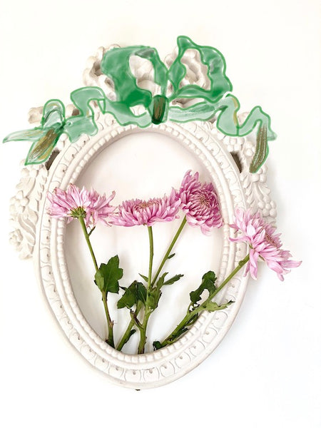 Frame from The Unfurling with intricate ribbon in oval