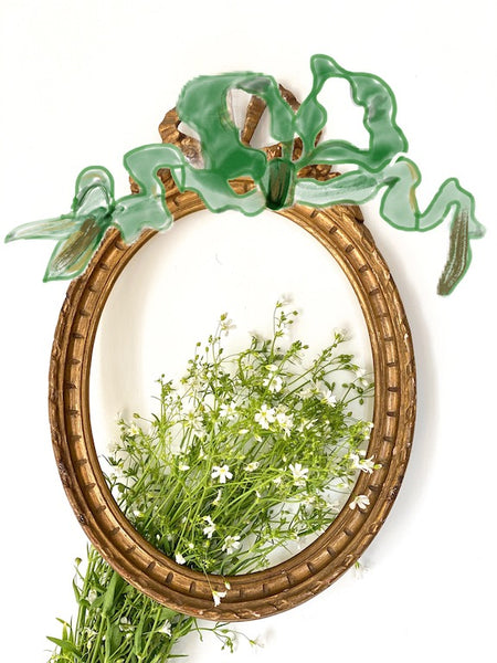 Frame in oval shape from The Unfurling with delicate ribbon