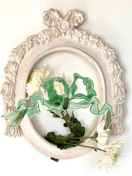 Frame in oval shape from The Unfurling with an outstanding ribbon