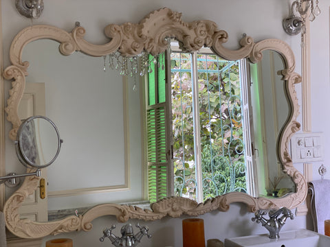 Custom hand carved rococo mirror frame in teak wood. White painted furniture and mirror frames for bathroom decor.