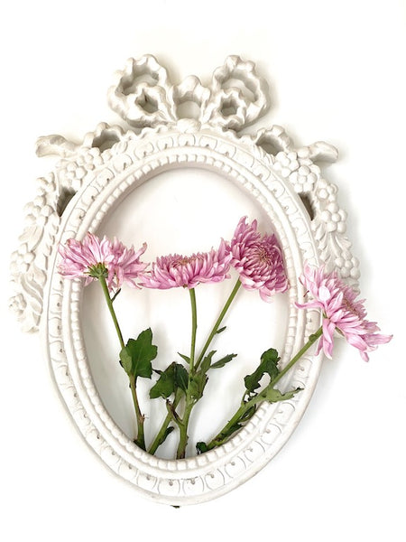 Frame from The Unfurling with intricate ribbon in oval