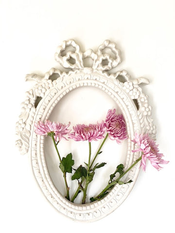 Frame from The Unfurling with intricate ribbon in oval
