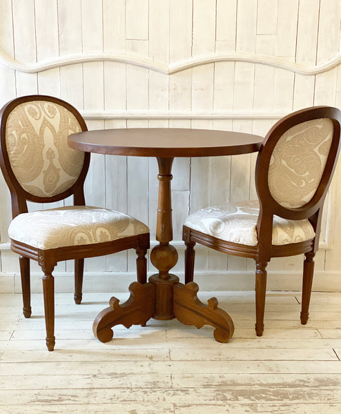 A set of two Louis XVI chairs with a petite table