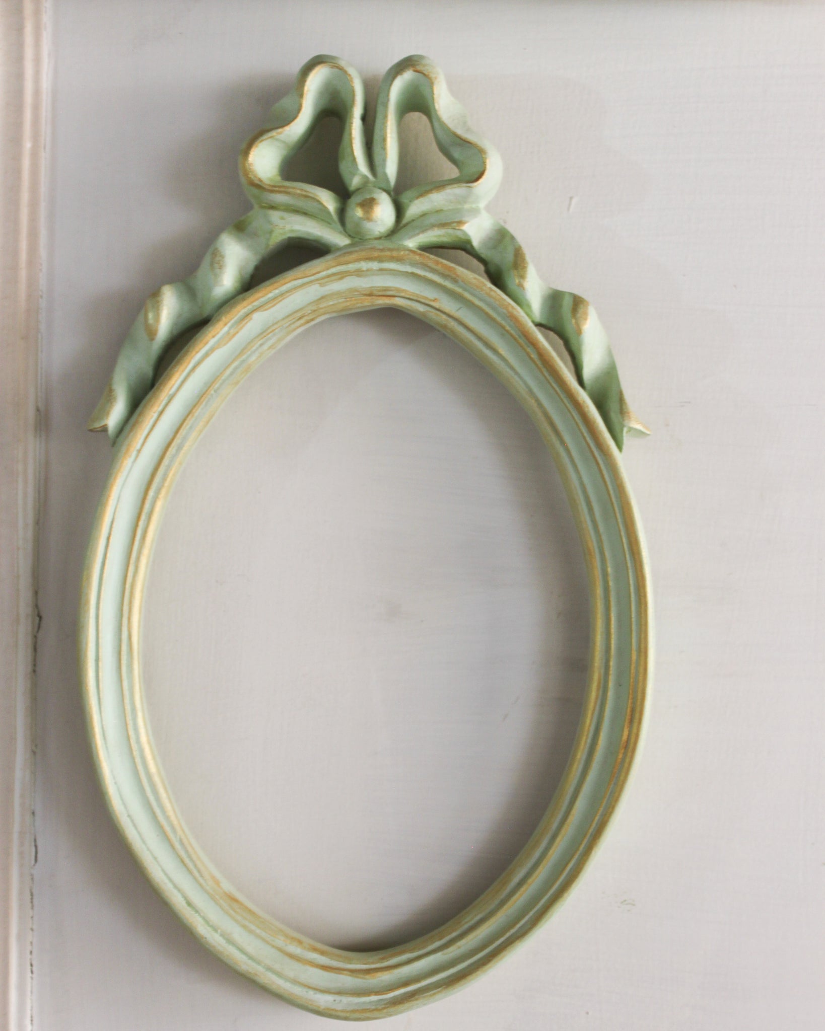 Diminutive oval Unfurling frame with delicate ribbon