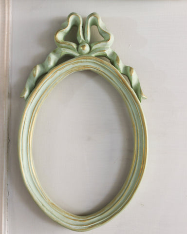 Diminutive oval Unfurling frame with delicate ribbon